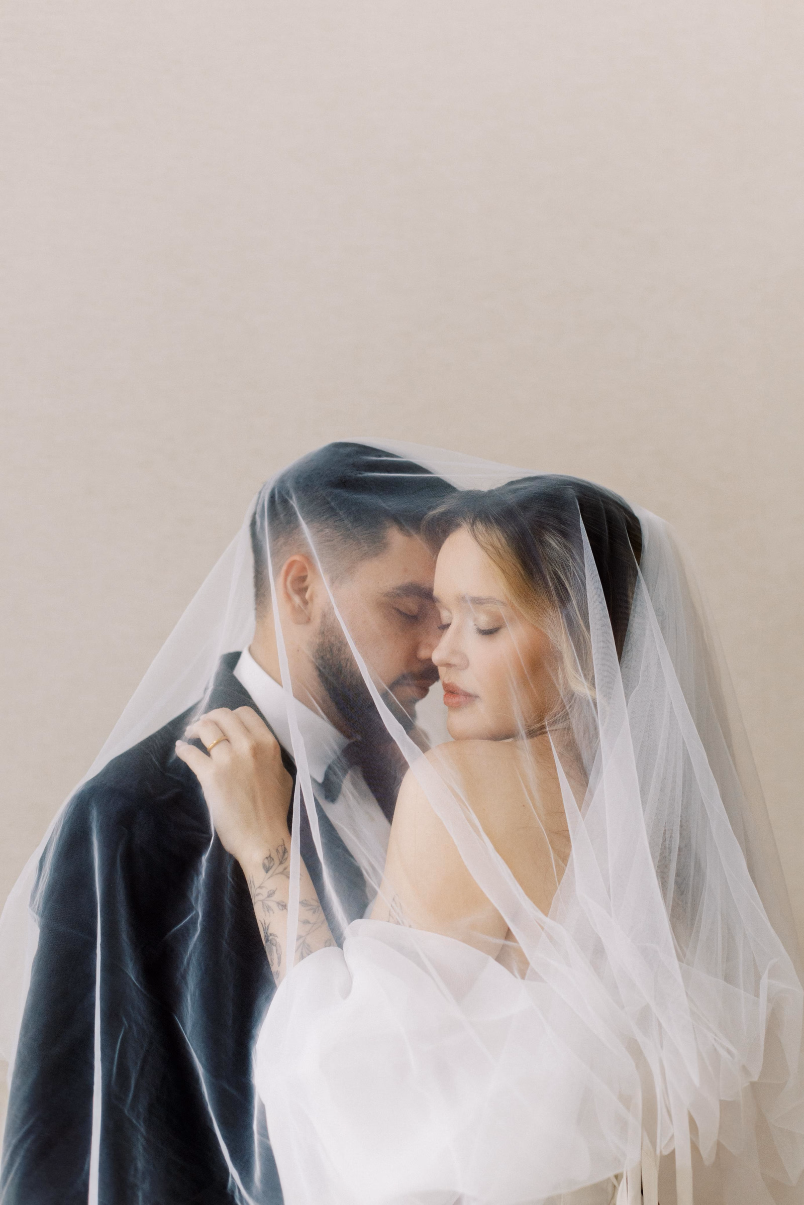 Casal sob véu translúcido em retrato de cerimônia